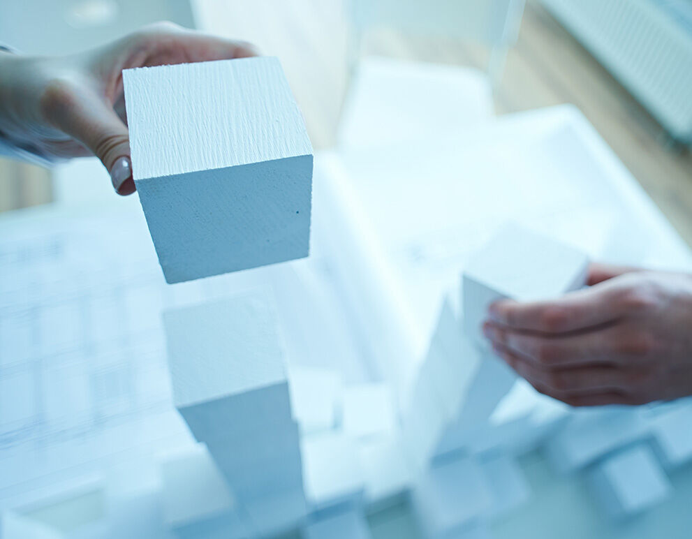 Hände, die Bausteine halten