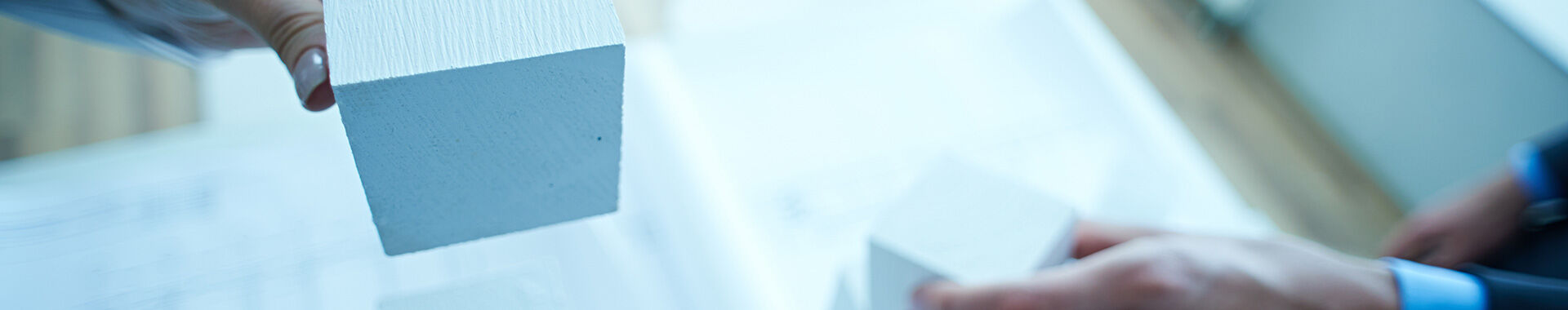 Hände, die Bausteine halten